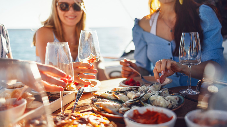 friends eating seafood together on a cruise together