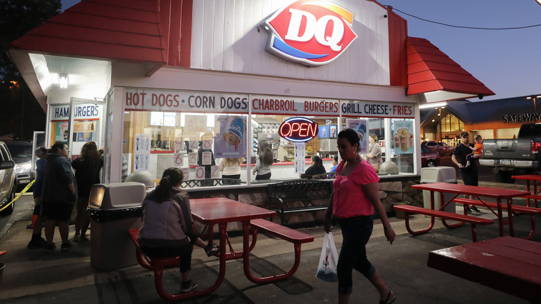 Customers wait in the dining area outside of a Dairy Queen at dusk