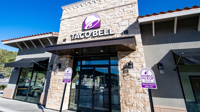 A Taco Bell location during the day time with a blue sky behind it