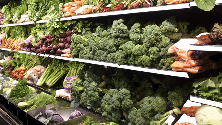 The produce section of a grocery store, featuring broccoli, carrots and celery