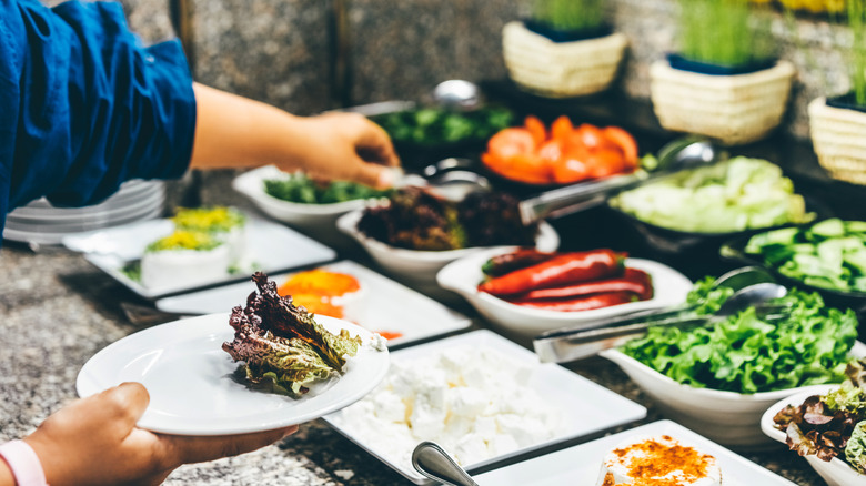 A person choosing food from a buffet table