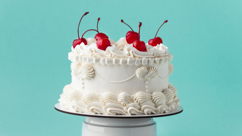 Lambeth-style cake in cream fondant, on seafoam green background