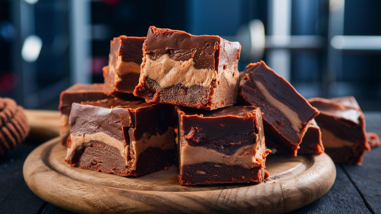 Peanut butter fudge protein squares on a wooden plate.