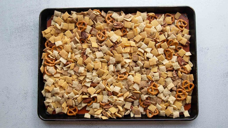 chex, pretzels, and pecans on a baking sheet