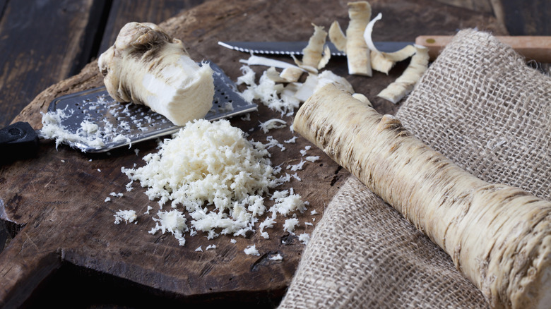 Horseradish root on cutting board with grater