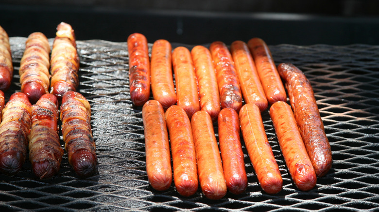 Hot dogs cooking on shaded grill