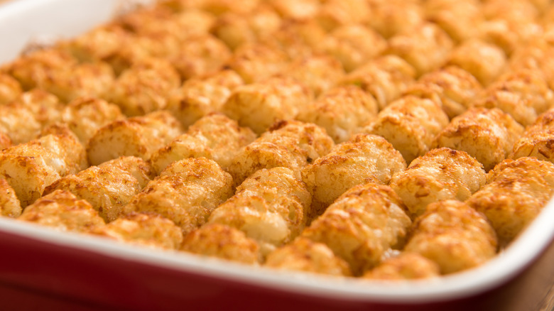 Close up of tater tot hotdish in a red baking pan