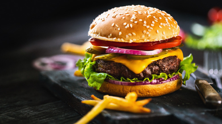 cheeseburger with lettuce, tomatoes and fries