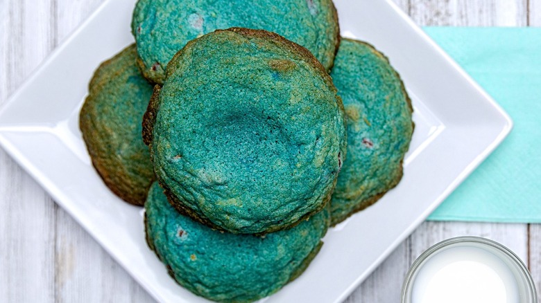 A stack of blue-green cookies on a white plate