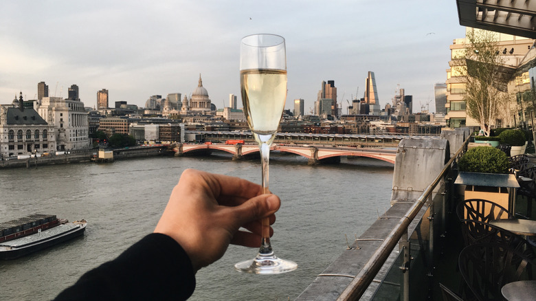 A glass of sparkling wine being raised to London.