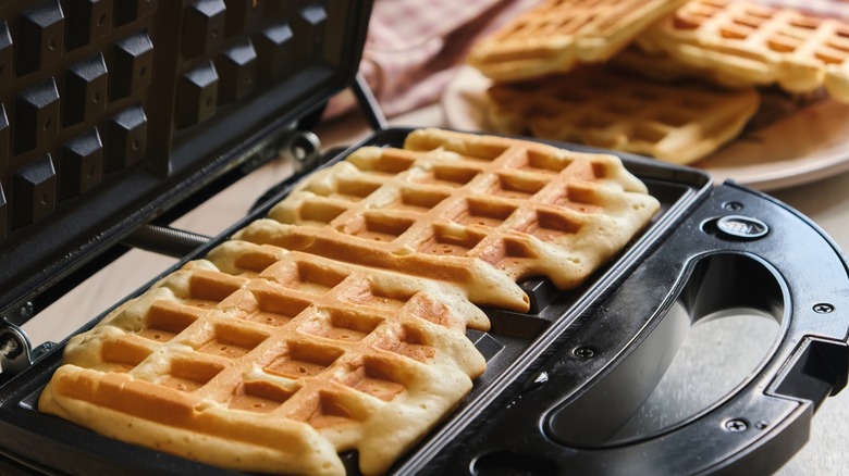 A close-up of waffles being made in a waffle iron