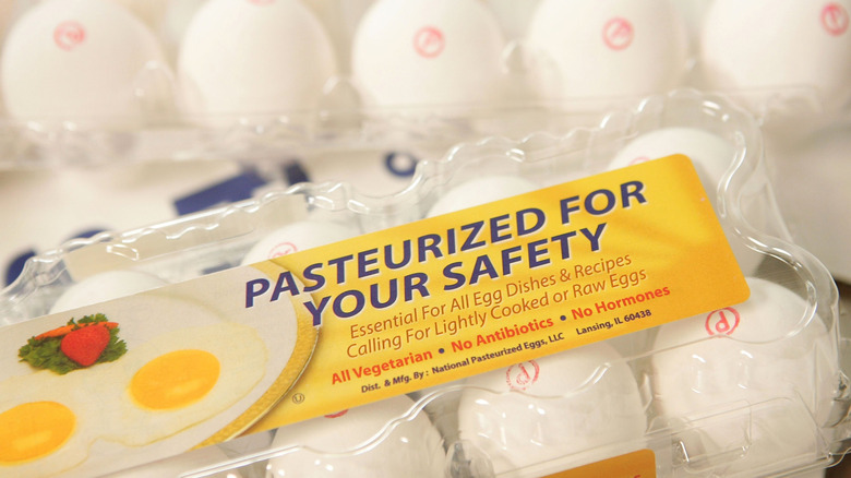 A carton of pasteurized eggs close to the camera.