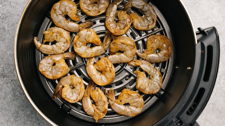 Shrimp cooking in air fryer basket