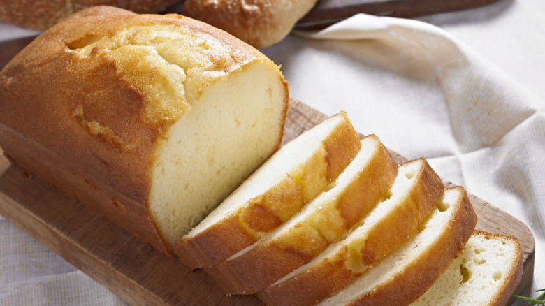 A sliced loaf of pound cake on a cutting board