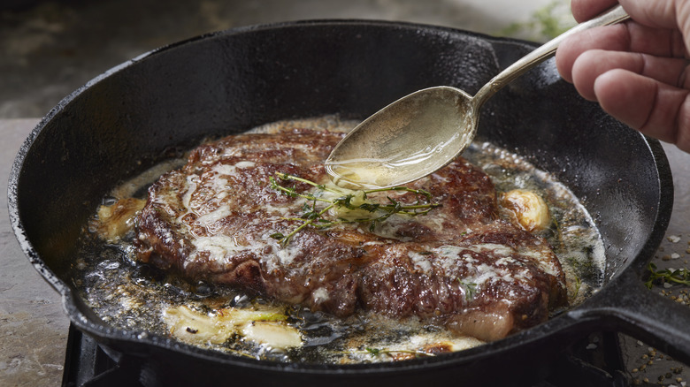 steak in hot pan basted with butter