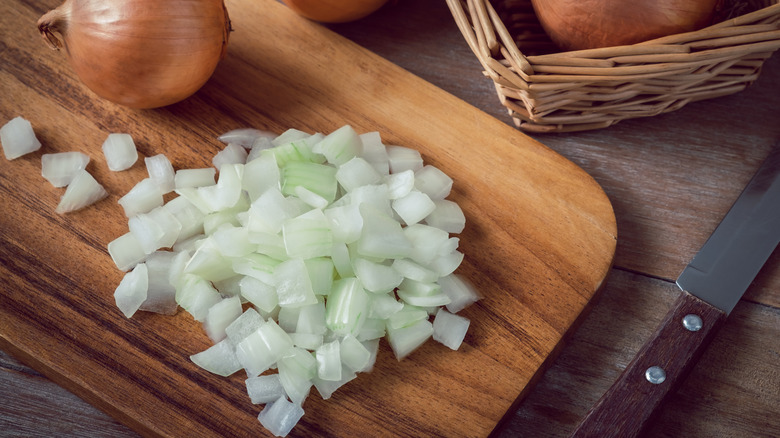 Chopped yellow onions on wooden cutting board