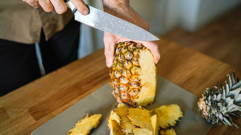 hand slicing fresh pineapple