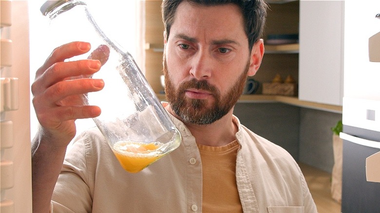 Person inspecting leftover orange juice