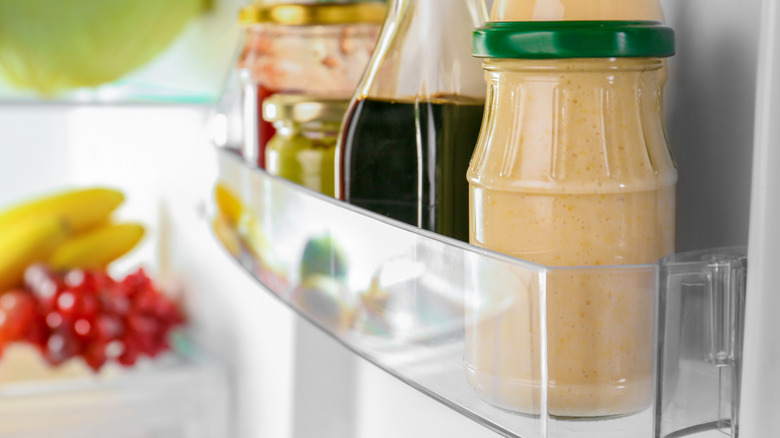 jars of condiments in a fridge door