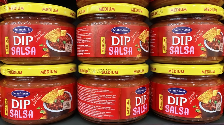 stacked jars of salsa on supermarket shelf