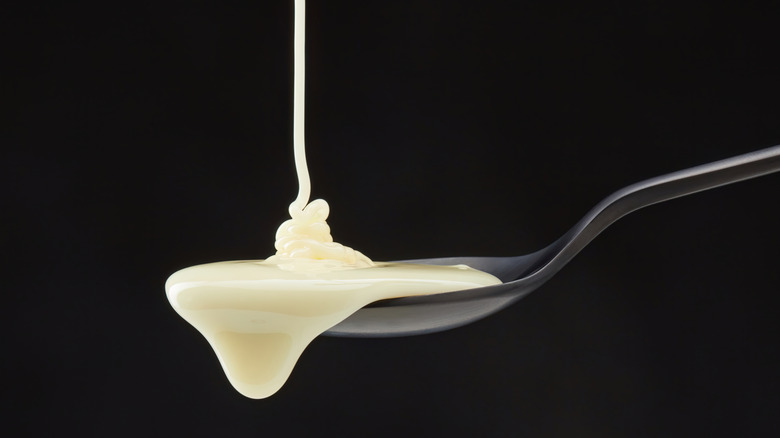 evaporated milk being poured onto a spoon