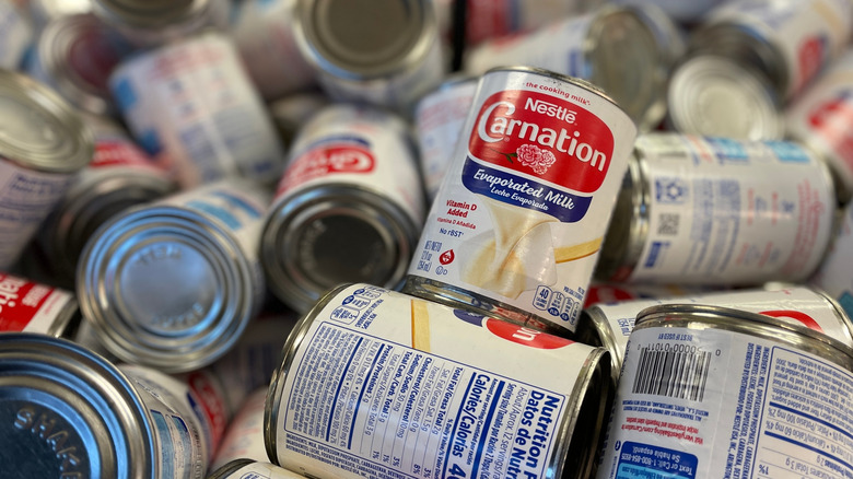 a pile of cans with one carnation evaporated milk label facing forward