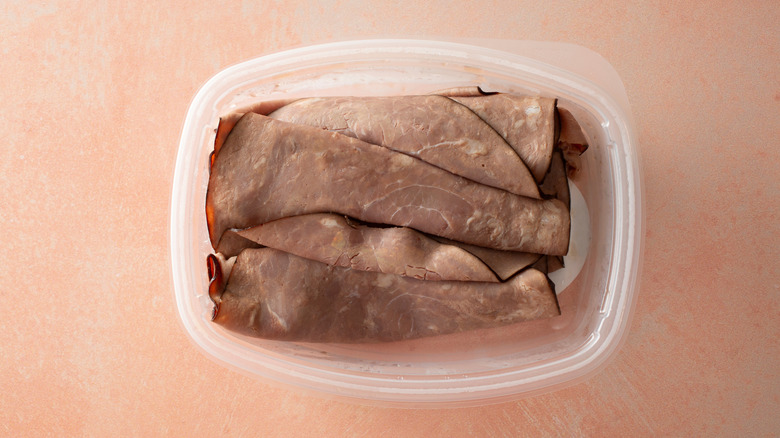 An overhead view shows roast beef slices in an open container