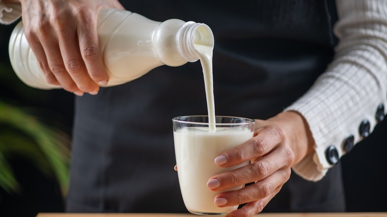 hand pouring kefir into a glass