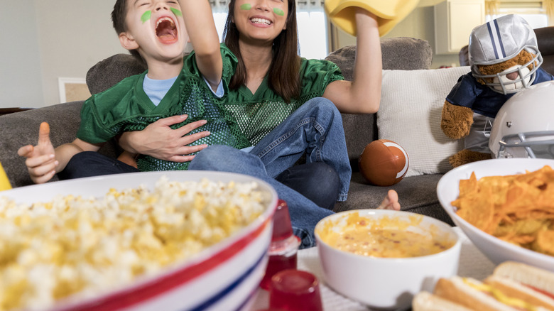 family watching football with queso in foreground