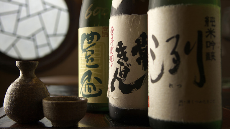 three bottles of sake with decanter and cup