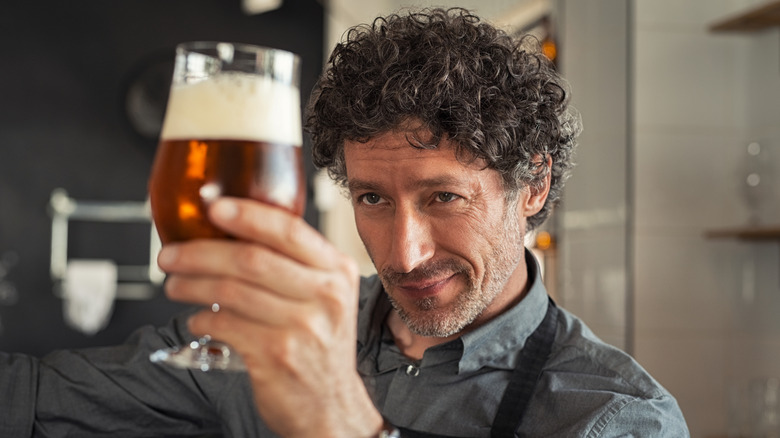 man inspecting beer