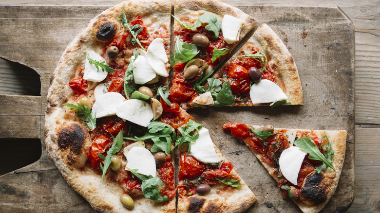 A pizza on a wooden cutting board