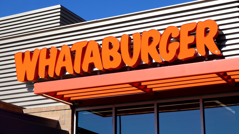 A Whataburger sign on the exterior of a Whataburger location during the day.