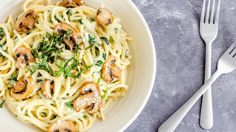 bowl of pasta with mushrooms in a white sauce