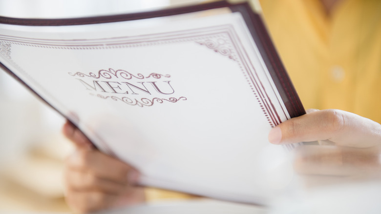 Close up shot of a customer holding a menu