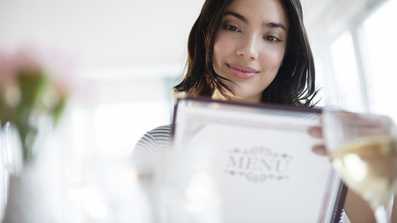 Woman reads a menu in a bright, modern restaurant