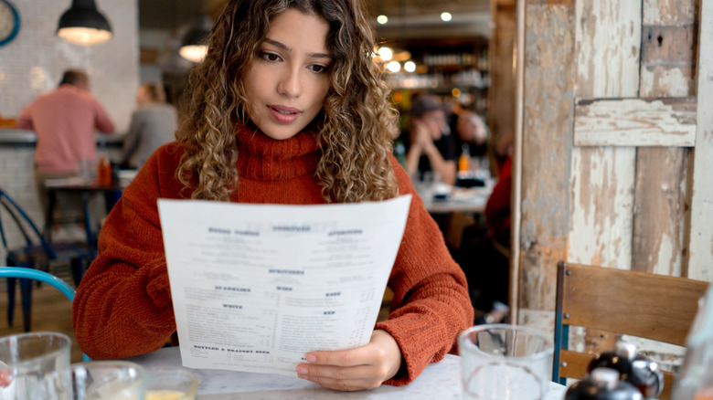 A woman reads a menu at a casual restaurant