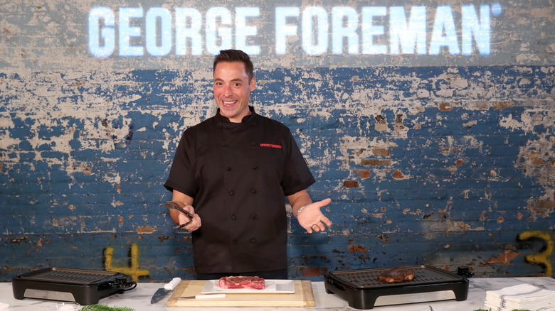 Jeff Mauro lifts his hands up in front of George Foreman grills