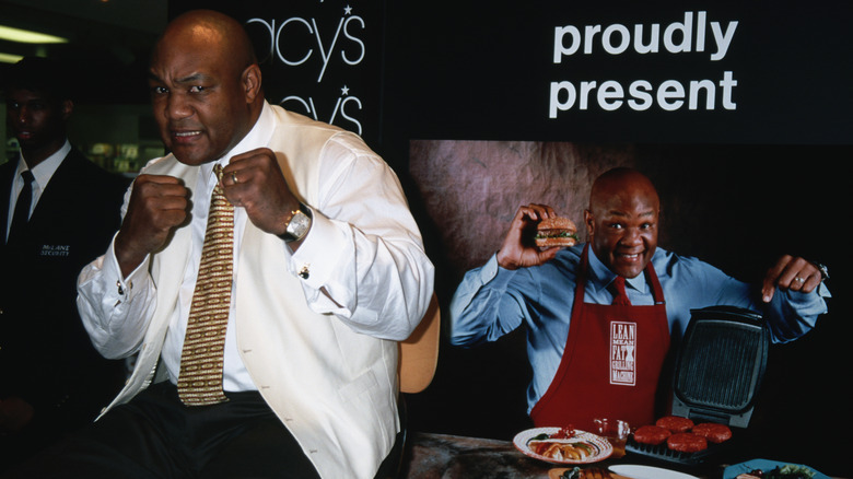 George Foreman sits next to a photo of himself