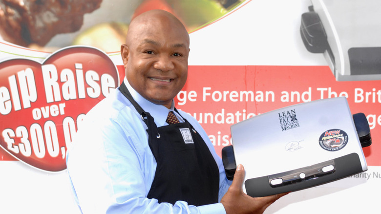 George Foreman holds up one of his namesake grills