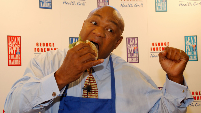 George Foreman takes a big bite out of a hamburger