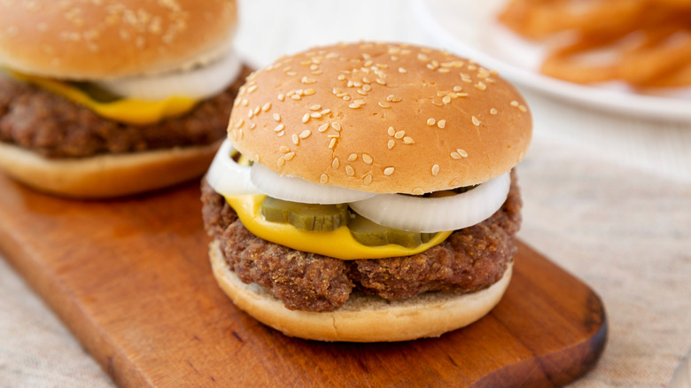 A slugburger served on sesame bun with mustard, pickles, onions.