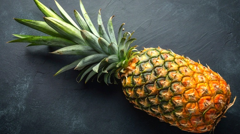 A ripe pineapple on a black surface