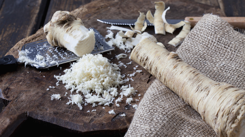 Horseradish root on cutting board with grater