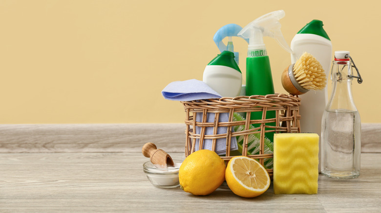 Basket with cleaning products including lemon juice, vinegar, and baking soda