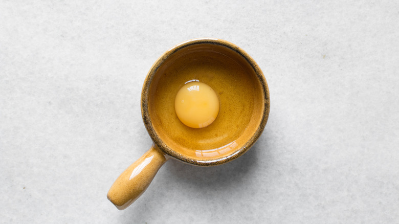 Ceramic ramekin with a cracked egg inside