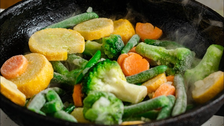 Frozen mixed vegetables cooking in skillet