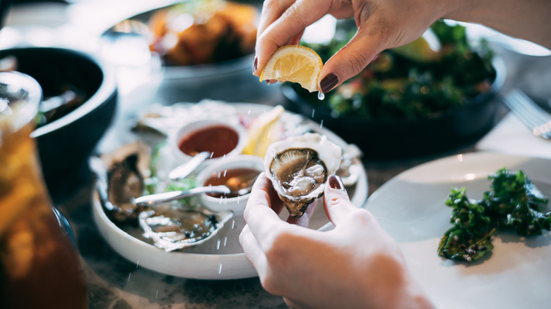 Squeezing lemon on oyster