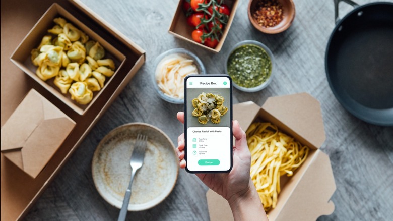 Mobile phone being held with in front of cooking ingredients.