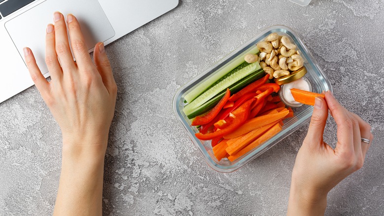 A person snacking on carrot sticks